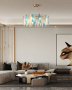 Clérachic chandelier with blue and clear glass leaves above a neutral living room with a low sofa.