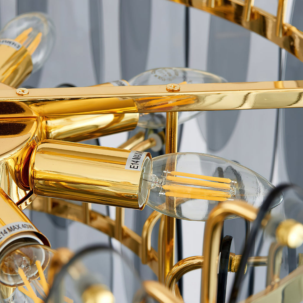Close view of a candle-style LED filament bulb in a gold holder inside this Clérachic chandelier.