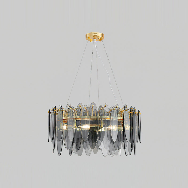 Clérachic chandelier with overlapping smoke grey glass leaves on a gold frame, lit against light grey.