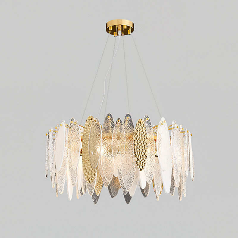 Wide Clérachic chandelier of clear glass leaves with gold hammered-look panels, lit on a grey backdrop.