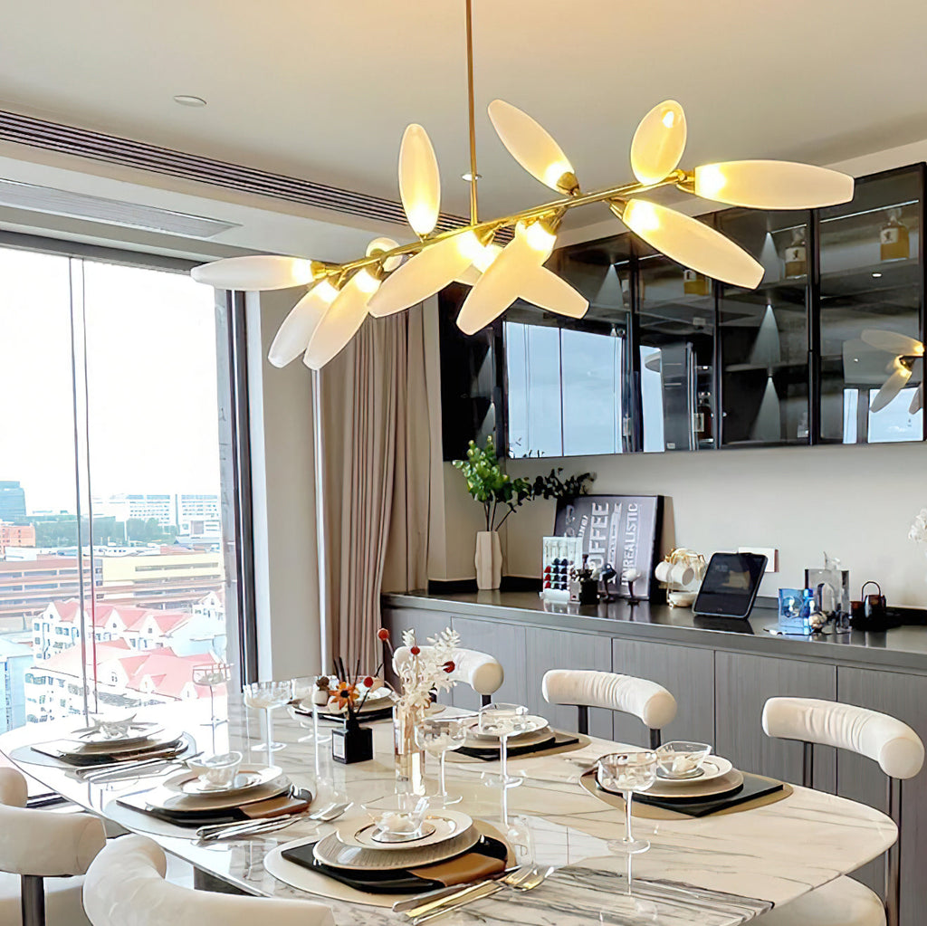 A Clérachic chandelier glows warm above a marble dining table set for a meal, with a glazed cabinet and a tall window behind.