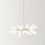 A round Clérachic chandelier on a gold ring and three fine wires, its frosted white glass leaves spread outward on a pale backdrop.