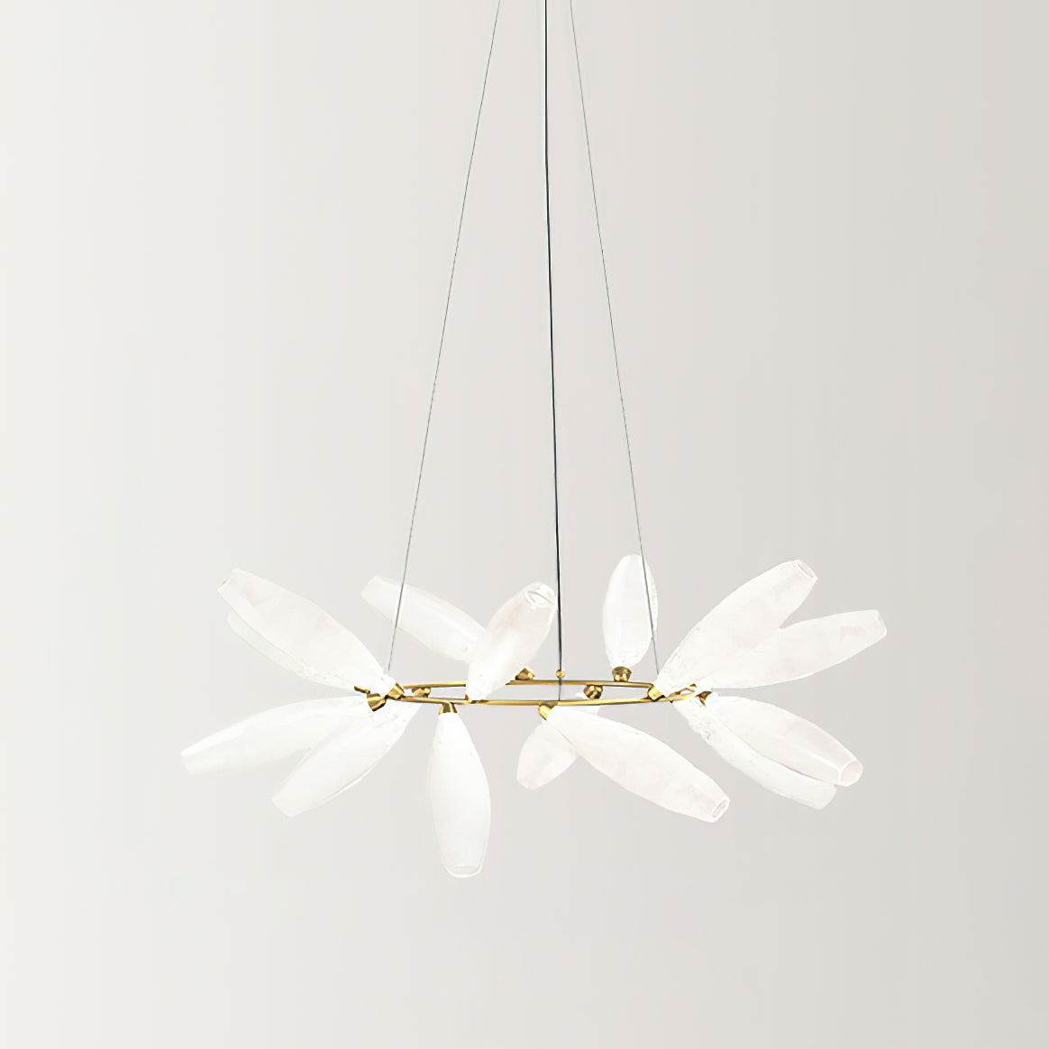 A round Clérachic chandelier on a gold ring and three fine wires, its frosted white glass leaves spread outward on a pale backdrop.