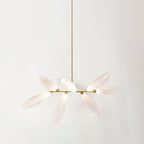 A short linear Clérachic chandelier of frosted glass leaves on a long gold rod, lit softly against a pale backdrop.