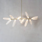 A linear Clérachic chandelier of frosted glass leaves on a gold bar hangs against a soft grey wall.