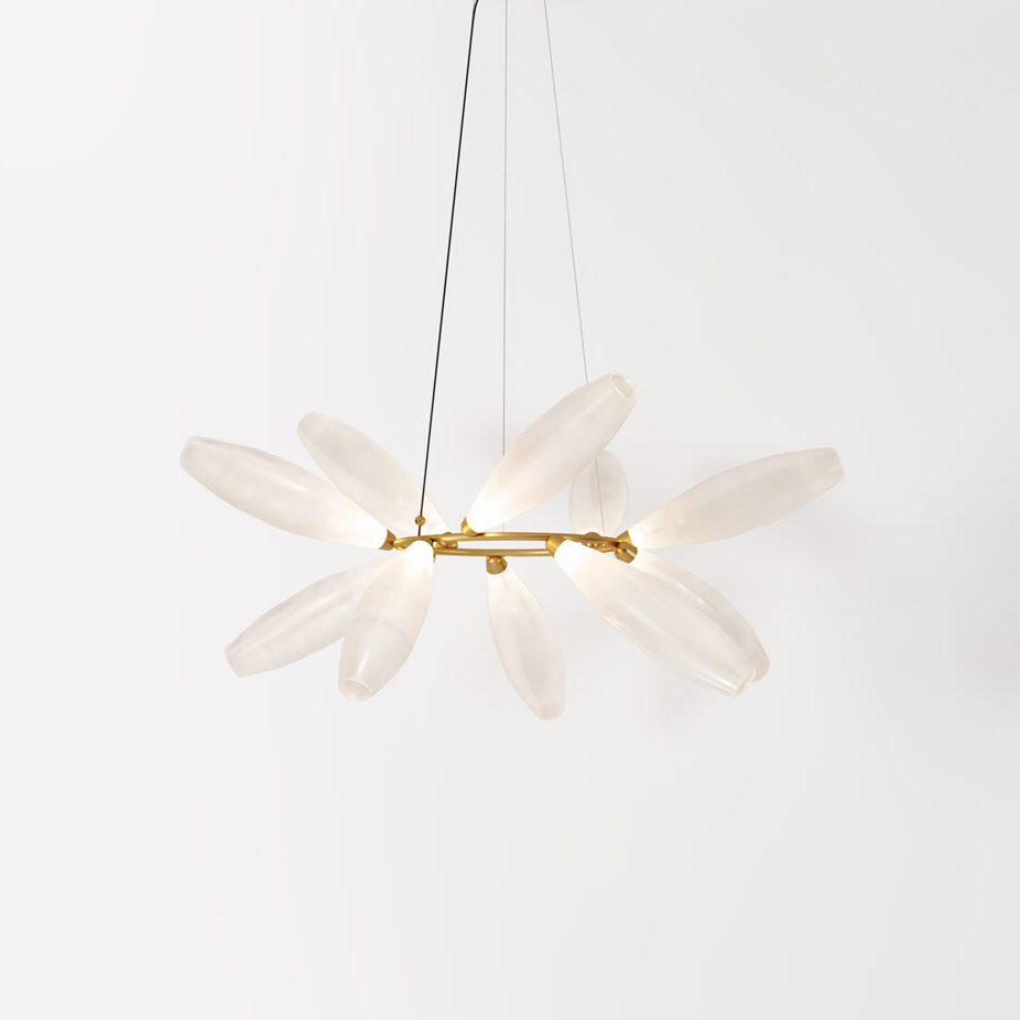 A round Clérachic chandelier seen from the side, its white glass leaves clustered around a thin gold ring on a pale backdrop.