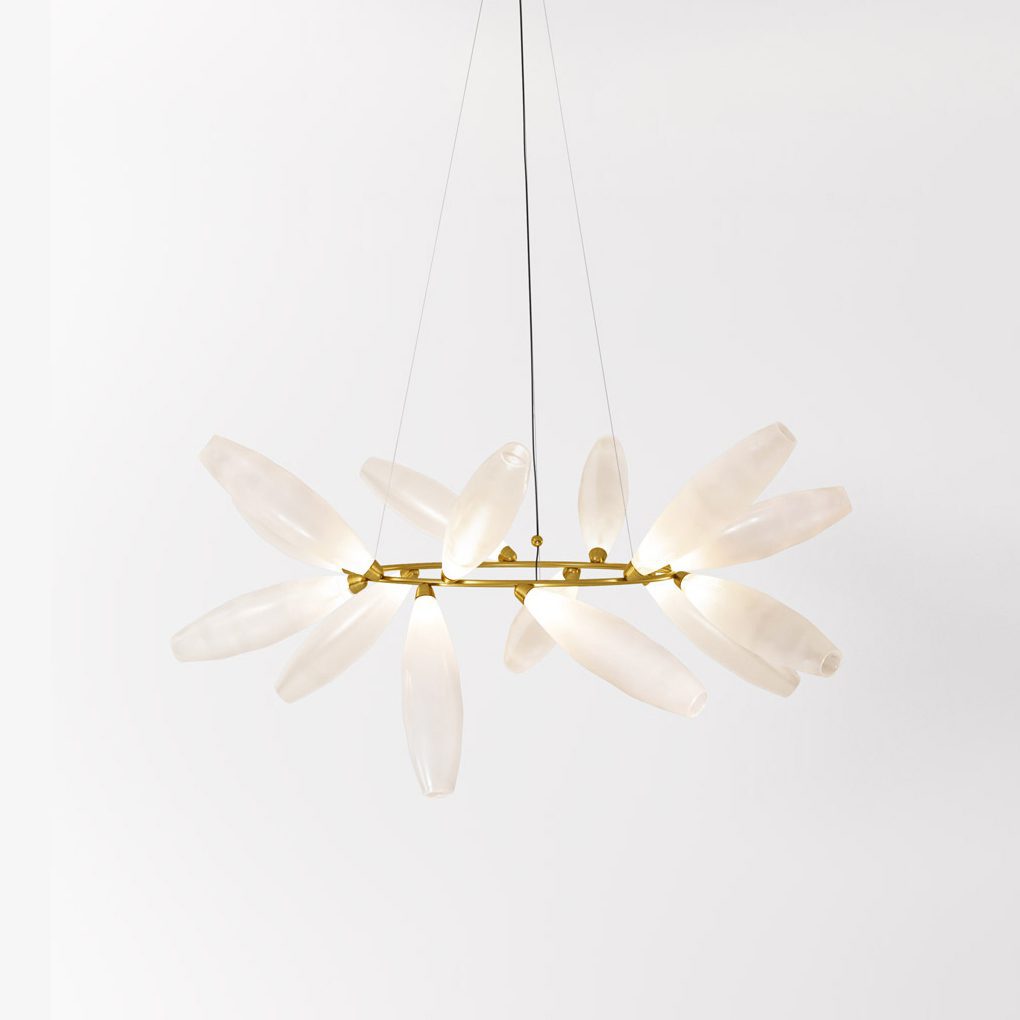 A round Clérachic chandelier with frosted white leaves fanning out from a gold ring, hung on three fine wires against a pale wall.