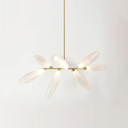 A short linear Clérachic chandelier of lit frosted glass leaves on a gold bar, hung from a gold rod against a pale wall.