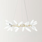 A round Clérachic chandelier in a clear glass finish, with transparent leaves on a gold ring and fine wires against a pale backdrop.