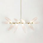 A linear Clérachic chandelier of lit frosted glass leaves on a gold bar, hung from a gold rod against a pale backdrop.