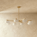 Clérachic eight-head chandelier shown unlit, with brass rod arms radiating from a central stem and frosted oval glass shades.