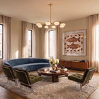 Clérachic eight-head brass chandelier lighting a living room with a curved blue sofa, olive armchairs and a walnut sideboard.
