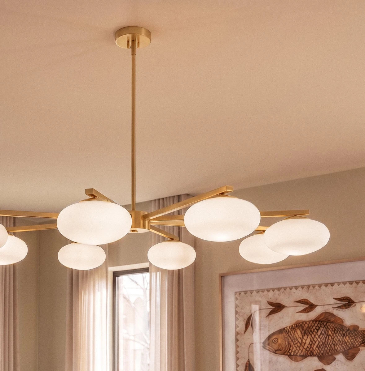 Close view of a Clérachic eight-head chandelier, showing the brass canopy, central stem and glowing opal glass shades.