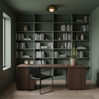 Above a walnut desk and sage green shelving, this Clérachic glass-disc ceiling light sits flush with the ceiling, its globe lit.