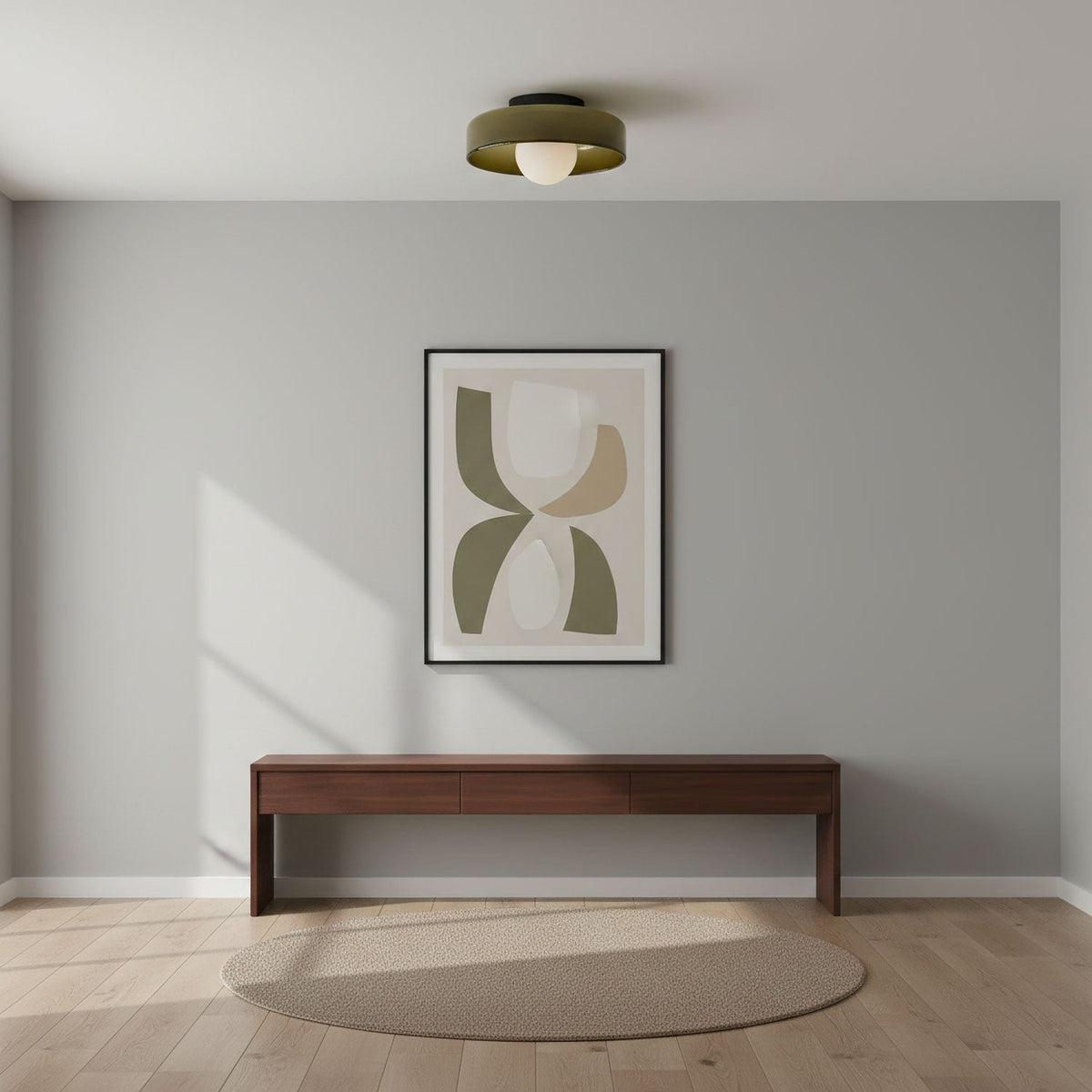 A Clérachic olive glass-disc ceiling light above a grey room with a walnut bench, a round jute rug and an abstract print.