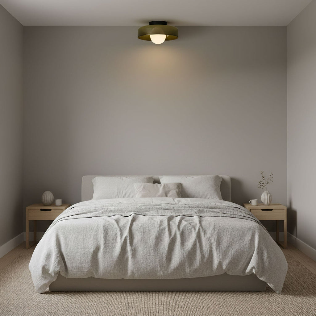 Above a bed with grey linen and two pale wood nightstands, a Clérachic ceiling light glows from the middle of the ceiling.