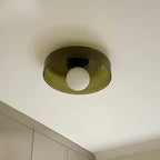 Seen from below, this Clérachic ceiling light has an olive smoked glass disc, a black plate and a frosted white globe.