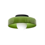 A Clérachic green glass-disc ceiling light with a black plate and a white globe, shown on a plain white backdrop.