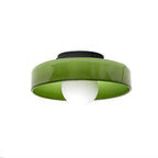 Green glass-disc ceiling light from Clérachic, with a black mounting plate and a white globe bulb hanging beneath.