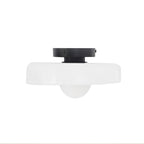 White glass-disc ceiling light from Clérachic with a black plate and a white globe underneath, on a plain white backdrop.