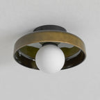 The Clérachic olive-brown glass-disc light switched off, its frosted white globe pale against a grey ceiling.