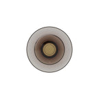 Front view of a Clérachic wall light with a smoked-glass disc, a gold centre cap and a thin dark rim, on a white backdrop.