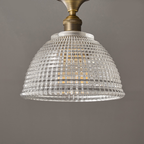 The clear ribbed glass dome of this Clérachic ceiling light, seen from below with its brass stem and white collar at the top.