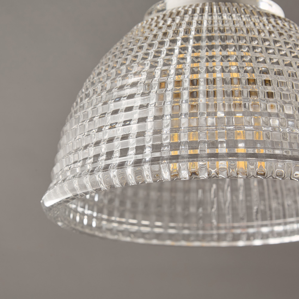 Close view of the grid-cut texture on the clear glass dome of this Clérachic ceiling light, with a bulb faintly visible inside.