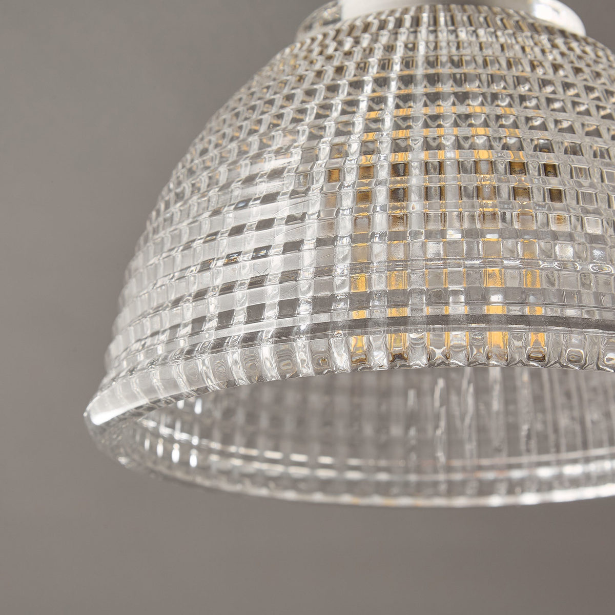 Close view of the grid-cut texture on the clear glass dome of this Clérachic ceiling light, with a bulb faintly visible inside.