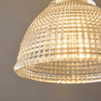 Close view of the lit glass dome on this Clérachic ceiling light, its grid pattern glowing a warm gold from the bulb within.