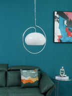 Unlit white version of this Clérachic pendant inside its chrome ring, against a teal wall with a colourful abstract print.