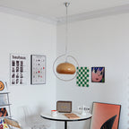 Small Clérachic pendant with a brown glass dome, in a bright room with posters, a round table and a retro speaker.
