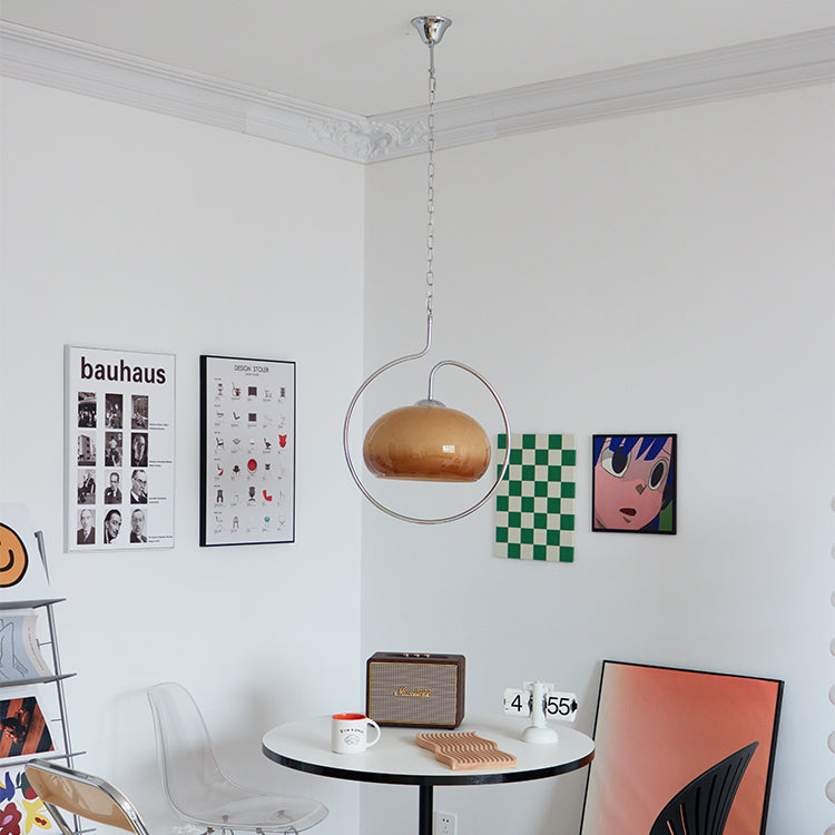 Small Clérachic pendant with a brown glass dome, in a bright room with posters, a round table and a retro speaker.