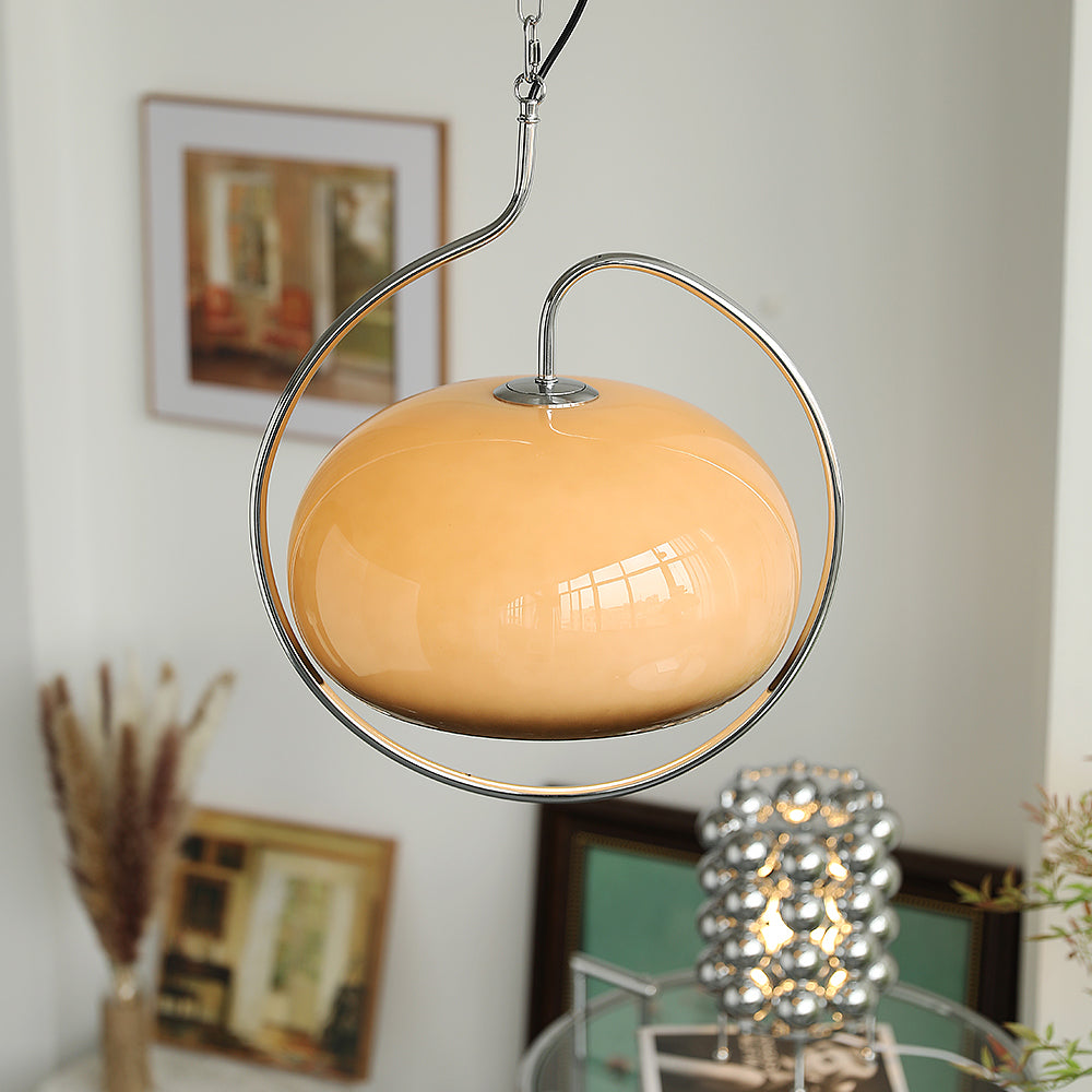Brown glass Clérachic pendant with a chrome ring in a room with framed pictures, dried pampas stems and a mirrored-bead lamp.