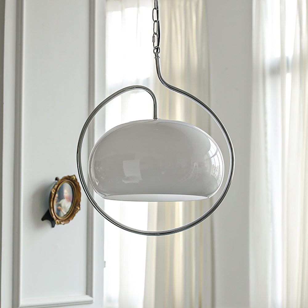 White glass Clérachic pendant inside a chrome ring, hung in a white panelled room next to a small ornate mirror and curtains.
