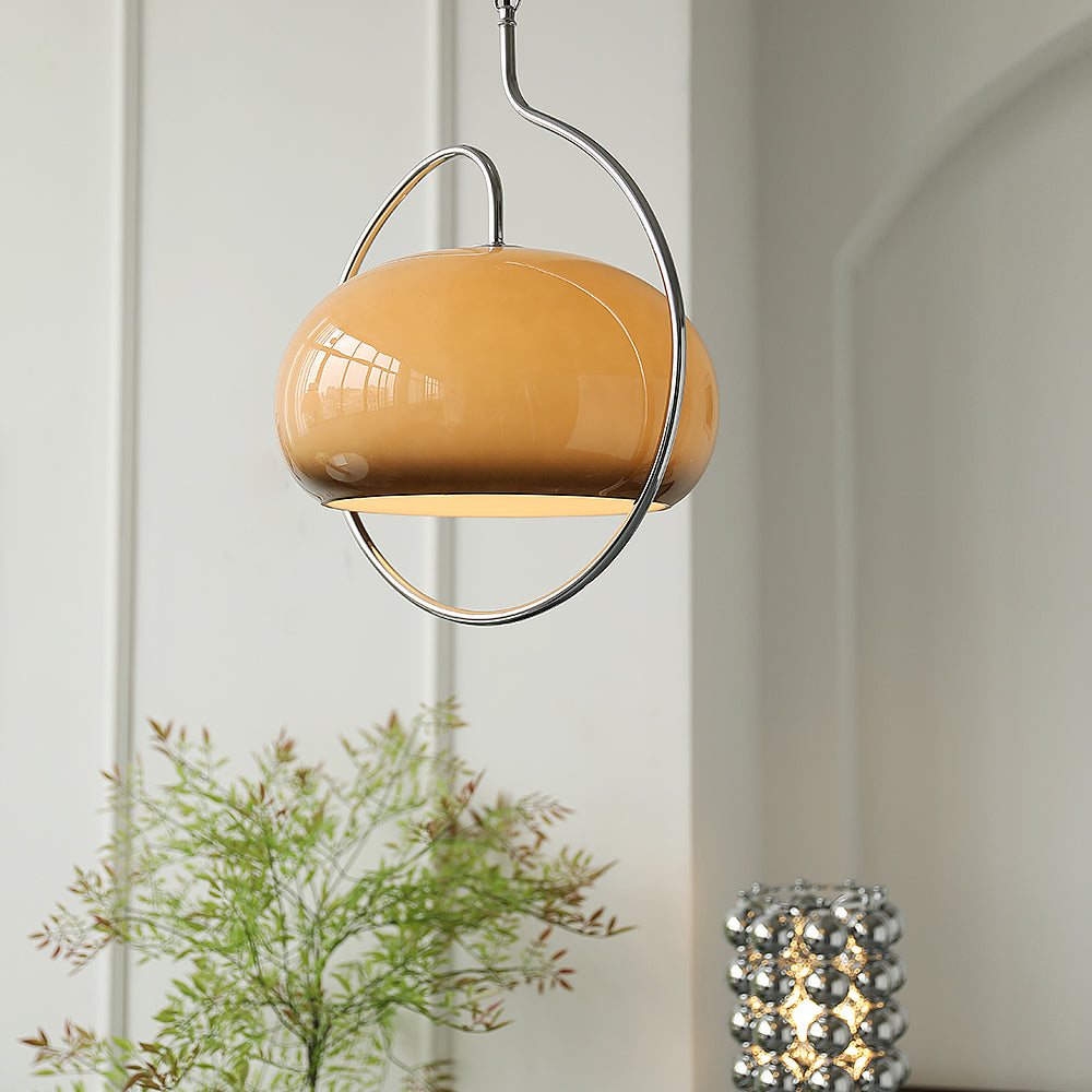 Brown glass Clérachic pendant with its chrome ring, seen in an arched white room with a green plant and a bead lamp below.