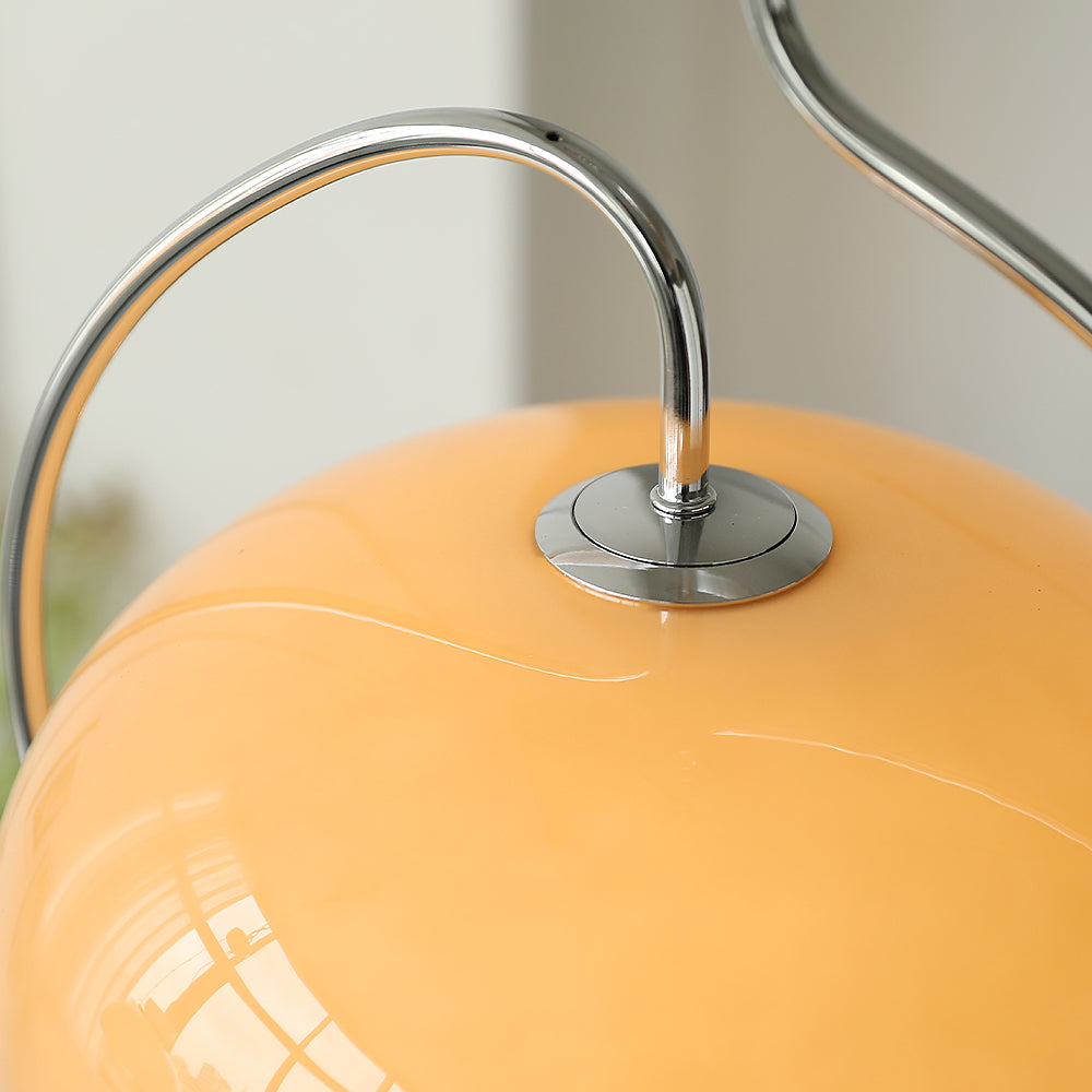 Close view of the chrome collar and curved arm joining the brown glass dome of this Clérachic pendant.