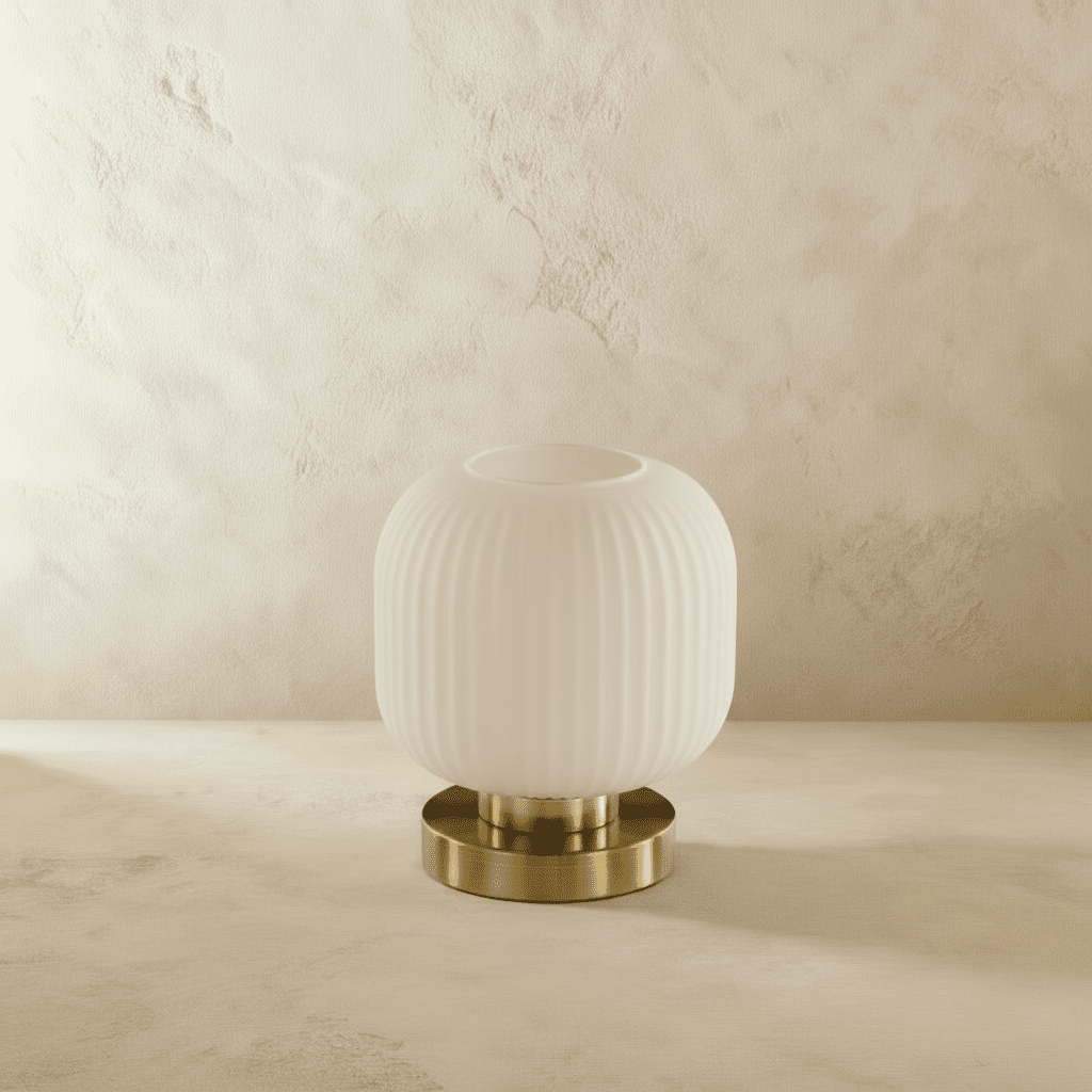 Clérachic ribbed glass dome table lamp in white, small silhouette unlit, brass base on a plaster surface.