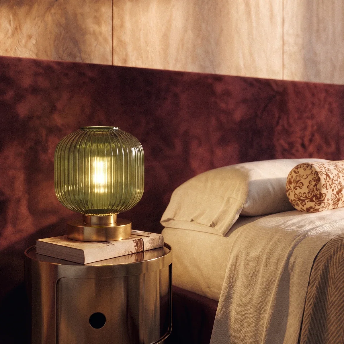 Clérachic ribbed glass dome table lamp in green, lit close on a brass drum nightstand beside a burgundy bed.