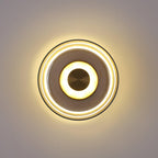 Lit against a grey wall, this Clérachic wall light shows a soft halo, a smoky glass ring and a brass centre disc.
