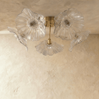 Clérachic five-head ceiling light switched off, showing clear ribbed glass flower shades on brushed brass arms and bulbs.