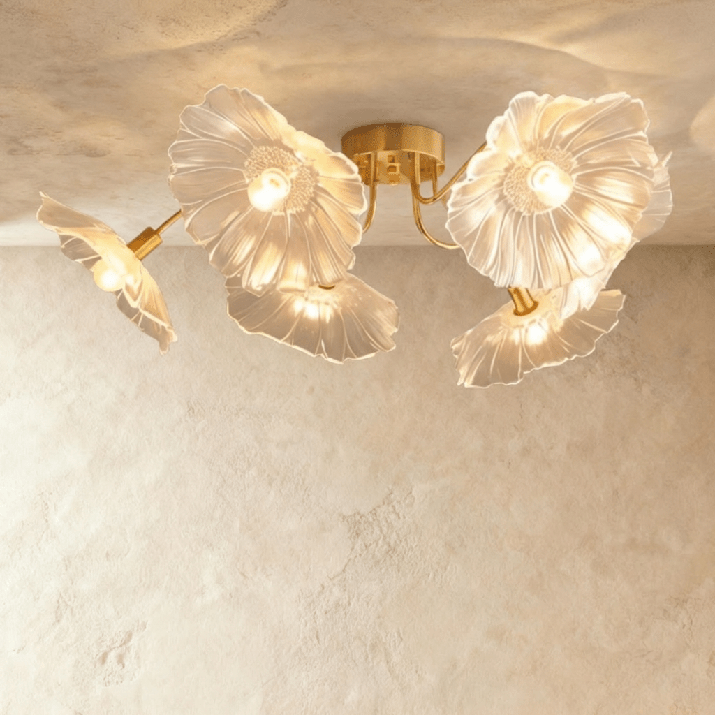 Clérachic six-head ceiling light with frosted clear glass flower shades on sweeping brass arms, seen from below.
