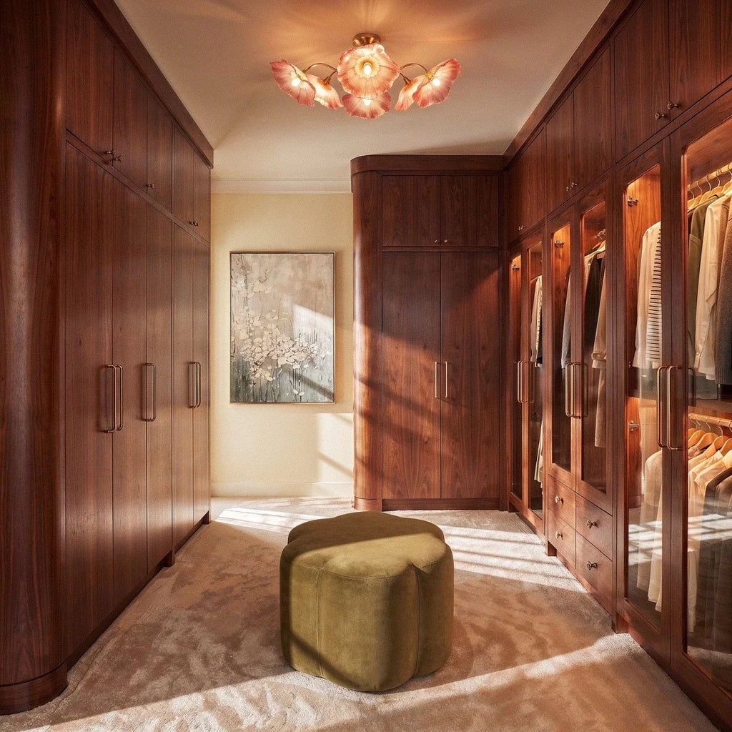 Clérachic red-toned glass flower ceiling light hung in a walnut-panelled dressing room above an olive velvet pouffe.