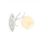 A white Clérachic wall light with a round opal glass shade and a carved oval backplate, on a white background.