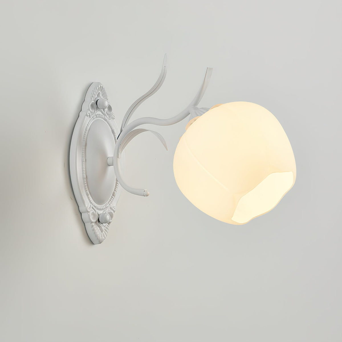 Angled close view of a white Clérachic wall light with a large opal glass shade and branch-style arm, on a grey wall.