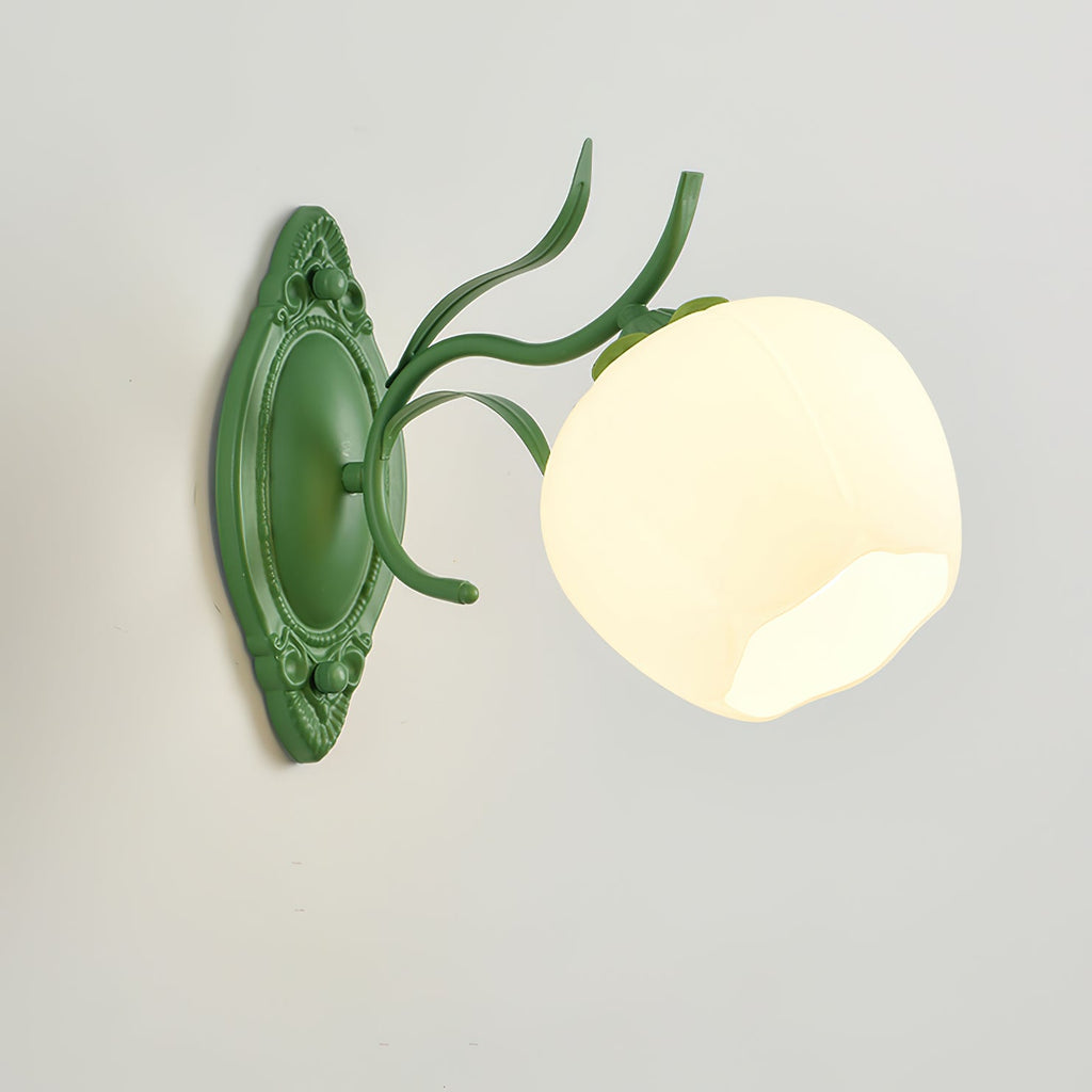 Green Clérachic wall light with a large round opal shade and a carved oval backplate, on a pale grey wall.