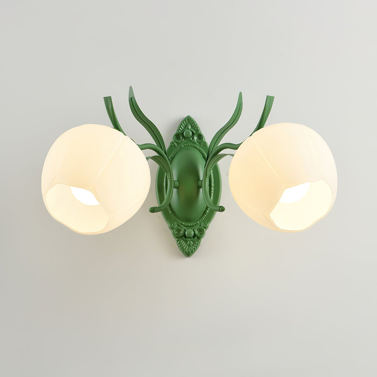Front view of a green Clérachic double wall light with two large opal glass shades, on a pale grey wall.