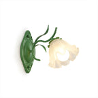 Green Clérachic wall light with one frilled frosted flower shade and leaf details, shown on a white background.
