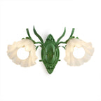 A green Clérachic double wall light with two ruffled frosted flower shades, lit, on a white background.