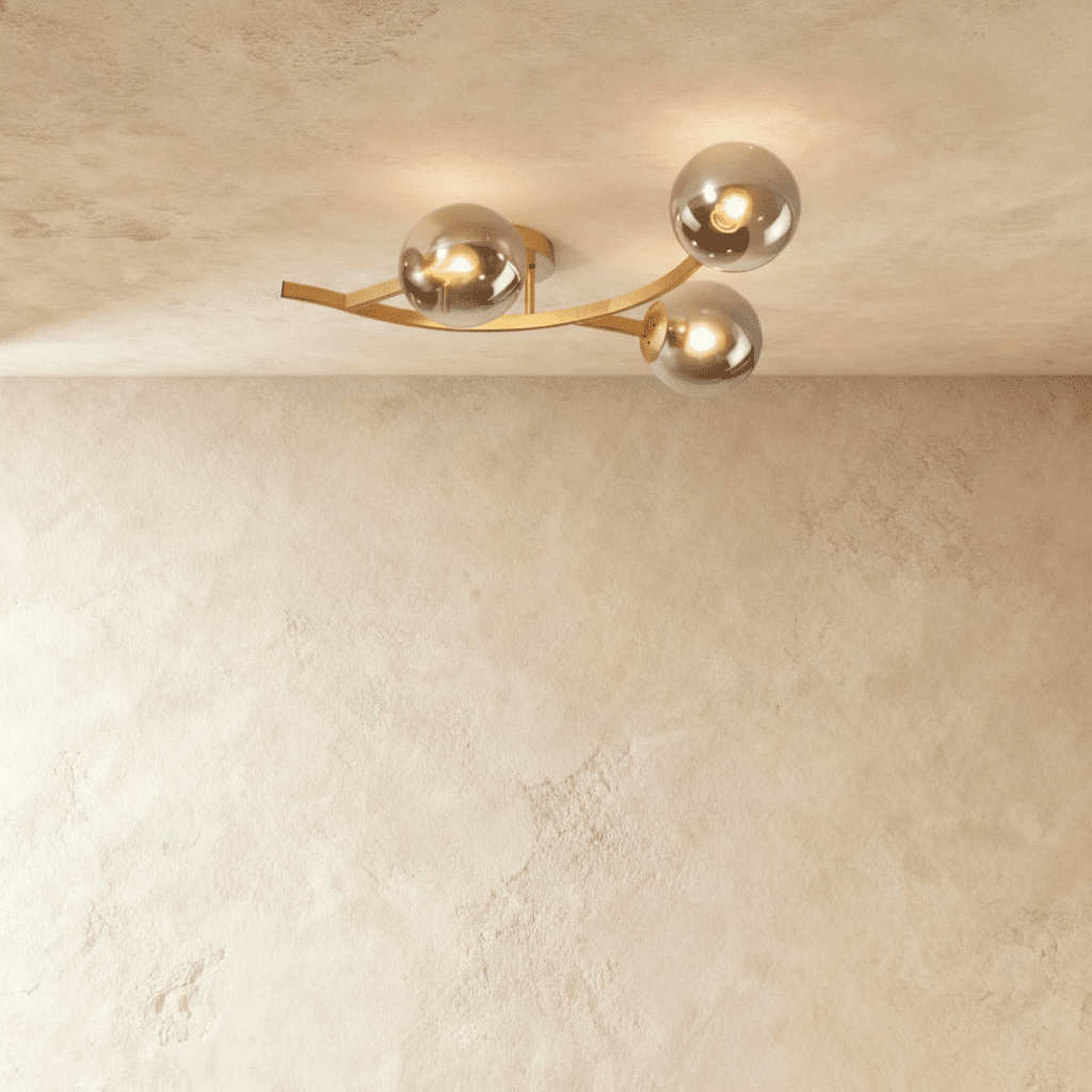 Clérachic three-globe ceiling light on a curved gold arm with smoked glass globes, each lit by a bare bulb.